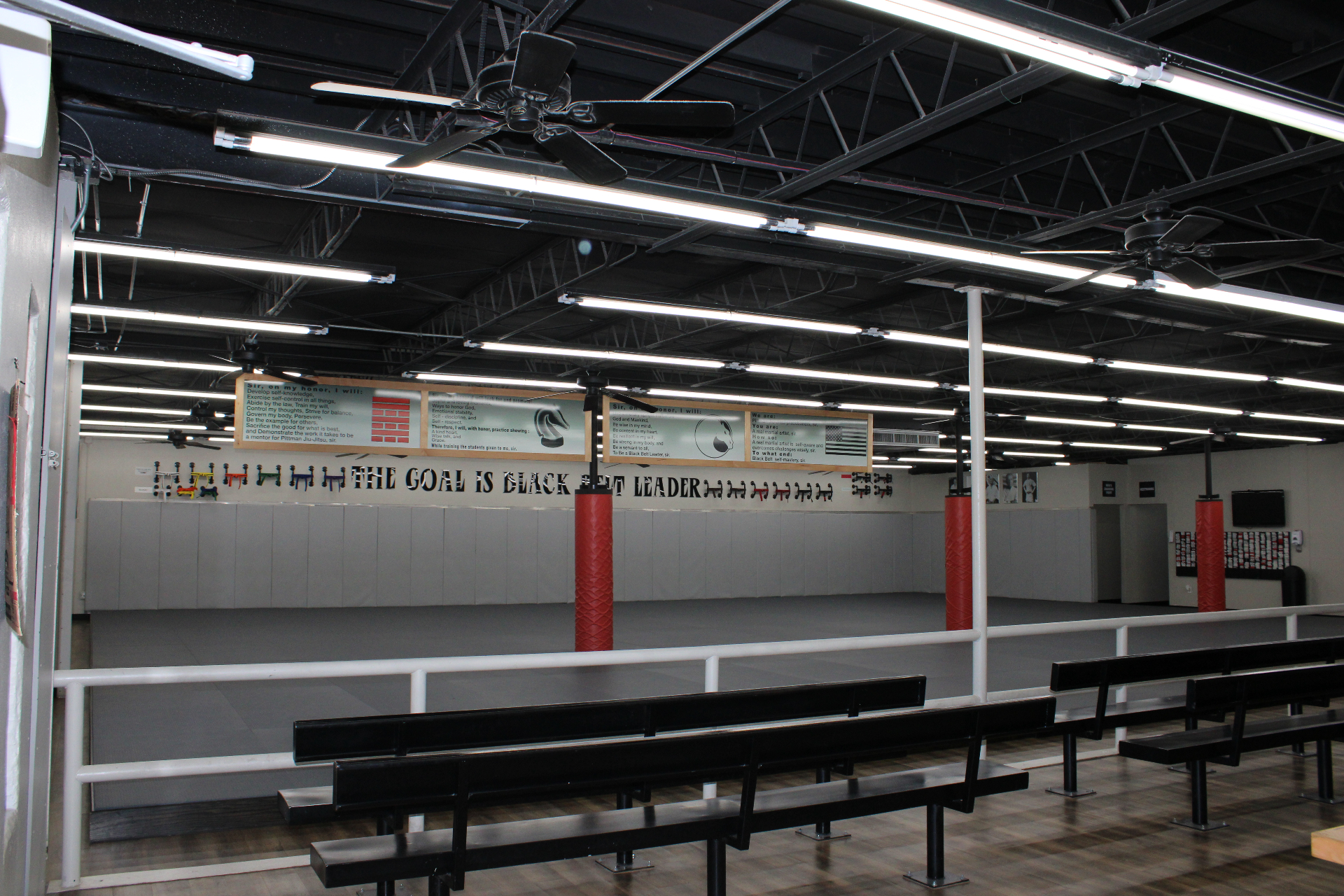 Inside the Lubbock Academy of Kids Martial Arts — large training mats and the 'Goal Is Black Belt Leader' wall